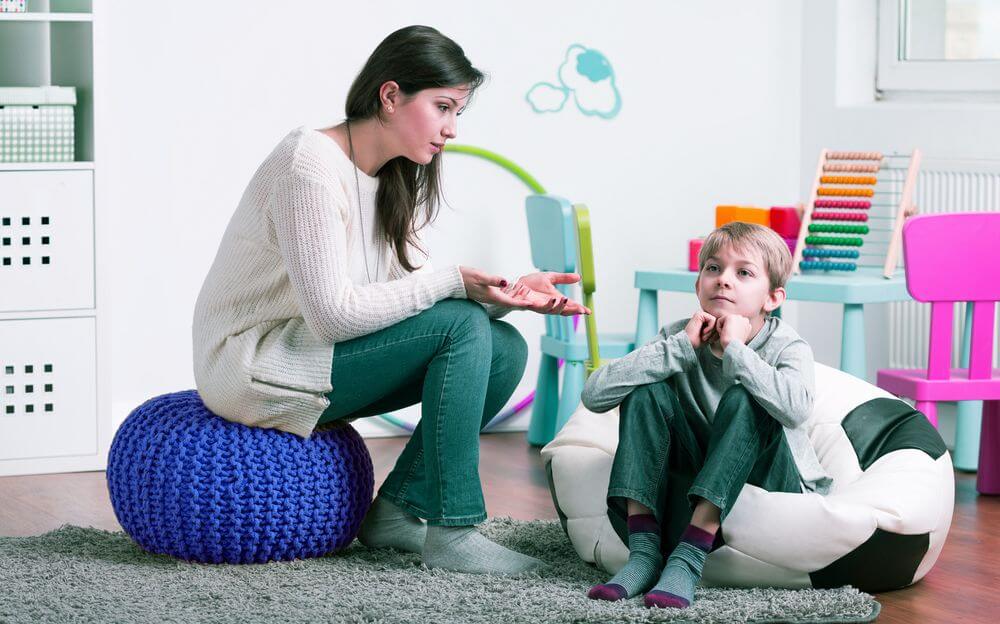 Female Child Psychologist Engaging With Young Boy