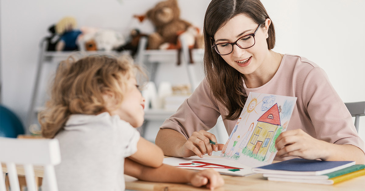 child psycholohist showing a hand drawn picture of a house to a child