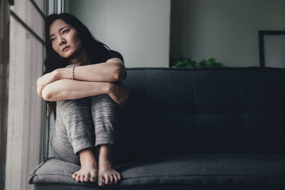 woman with anxiety sitting on couch