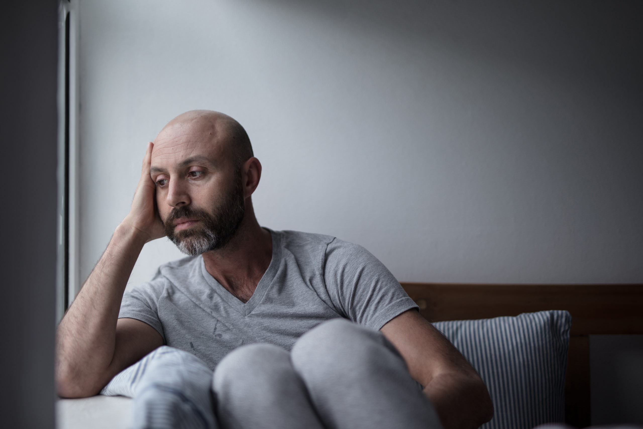 mid forties depressed man in bed at home