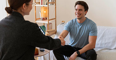 Man shaking therapist's hand during counselling session