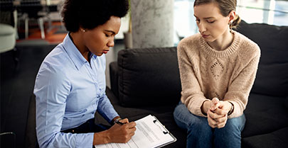 therapist looking down at notes while sat with client