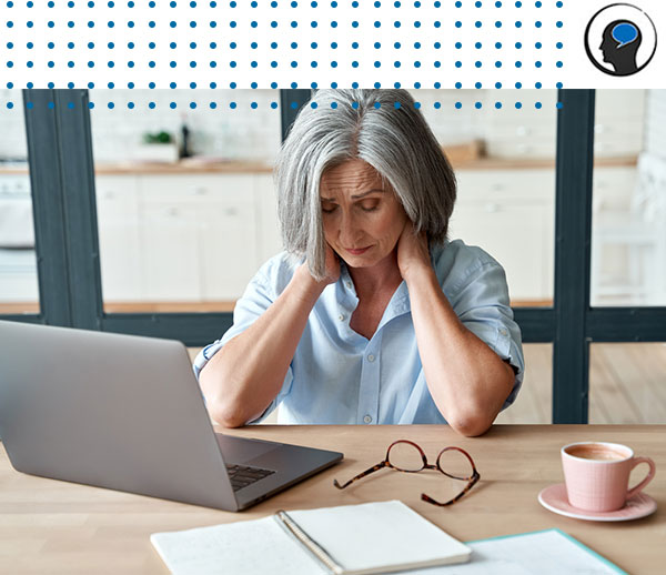 Woman sitting at desk and holding neck in pain