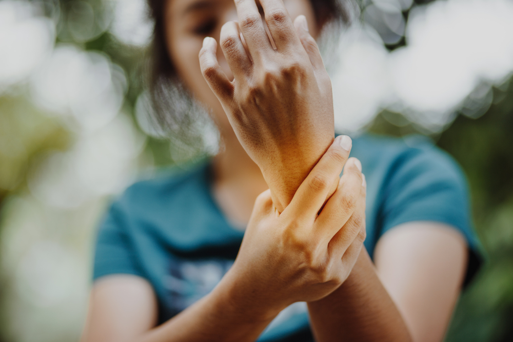 young woman holding wrist in pain